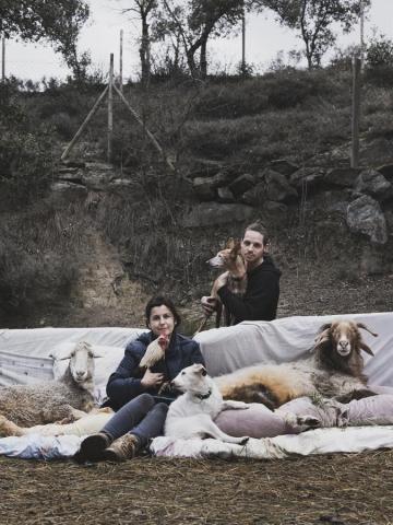 Retrato de Familia de Elena, fundadora de la Fundación El Hogar, y su pareja Kevin, en el campo, junto con las ovejas Anna y Bebe Gary, el gallo Tutankamón y las perras Gretel y Julieta.