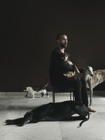 Retrato de Familia de Elena, fundadora de la Fundación El Hogar, y su pareja Kevin, en el campo, junto con las ovejas Anna y Bebe Gary, el gallo Tutankamón y las perras Gretel y Julieta.